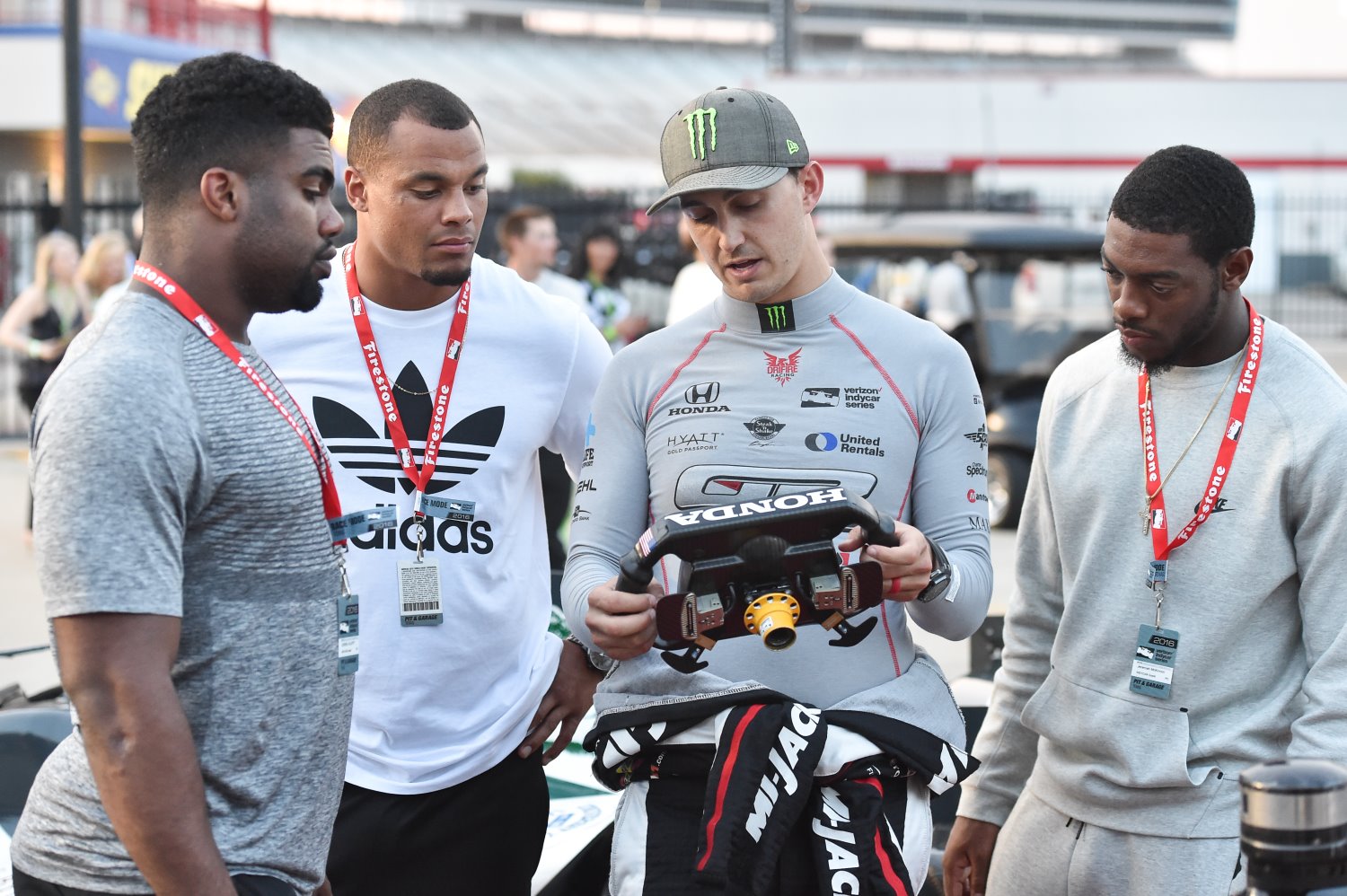 Rahal shows Dallas Cowboy players what all the buttons on his steering wheel do