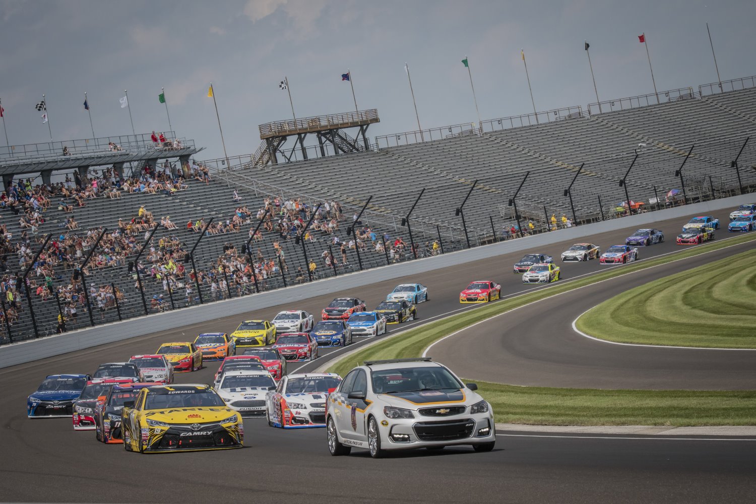 The heavy wallowing NASCAR Stock cars on the flat Indy track result in boring racing 