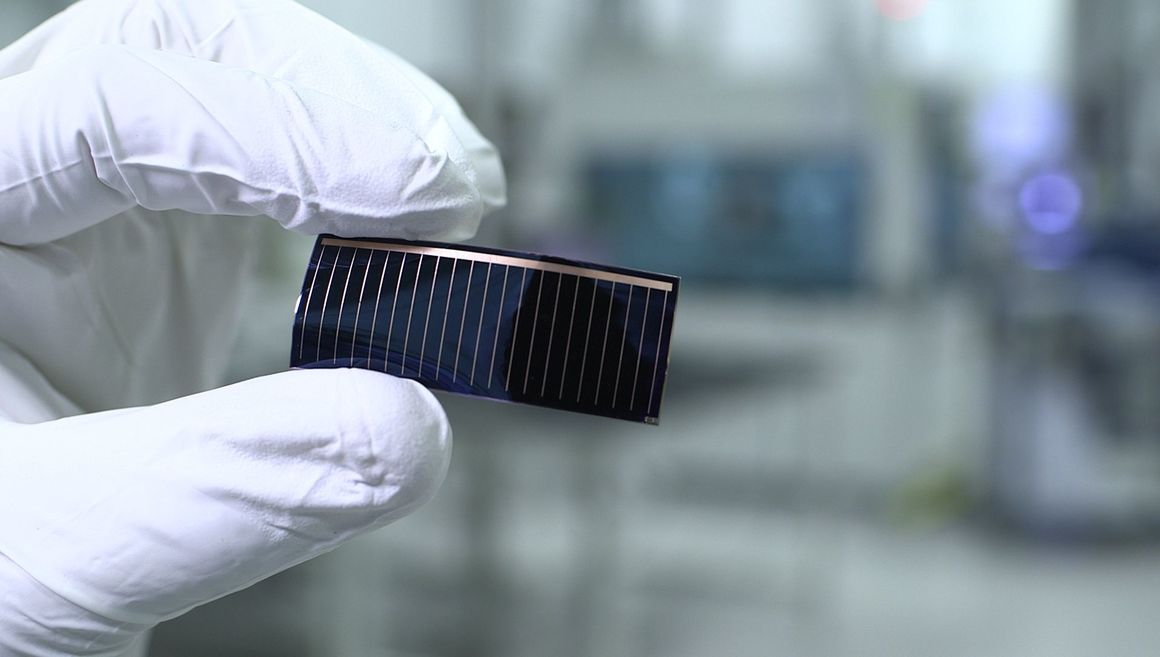 A worker holds thin-film solar cells that will be used in Audi's panoramic glass roof. Photo credit: Audi
