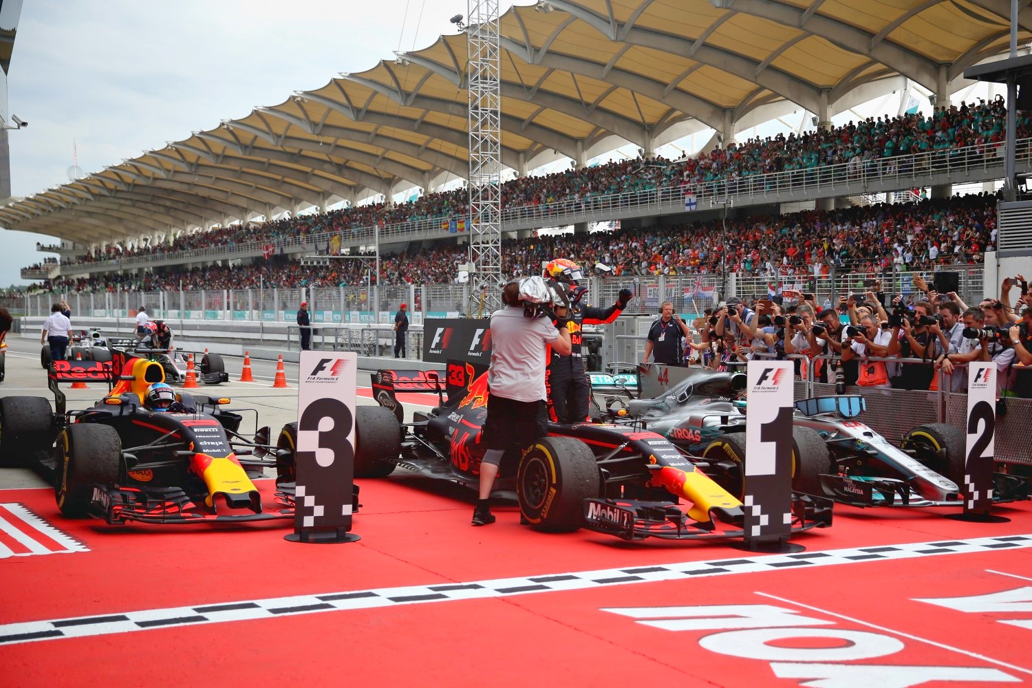 Race winner Max Verstappen of Netherlands and Red Bull Racing, second place finisher Lewis Hamilton of Great Britain and Mercedes GP and third place finisher Daniel Ricciardo of Australia and Red Bull Racing in parc ferme during the Malaysia Formula One Grand Prix at Sepang Circuit on October 1, 2017 in Kuala Lumpur, Malaysia. (Photo by Will Taylor-Medhurst/Getty Images)