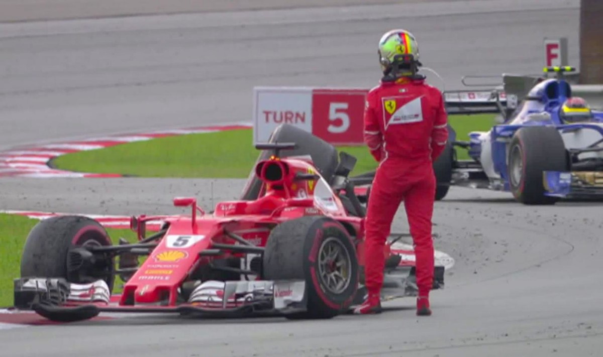 Vettel stands by his damaged car. His title hopes are over