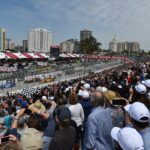 The sundrenched crowd watches the race start