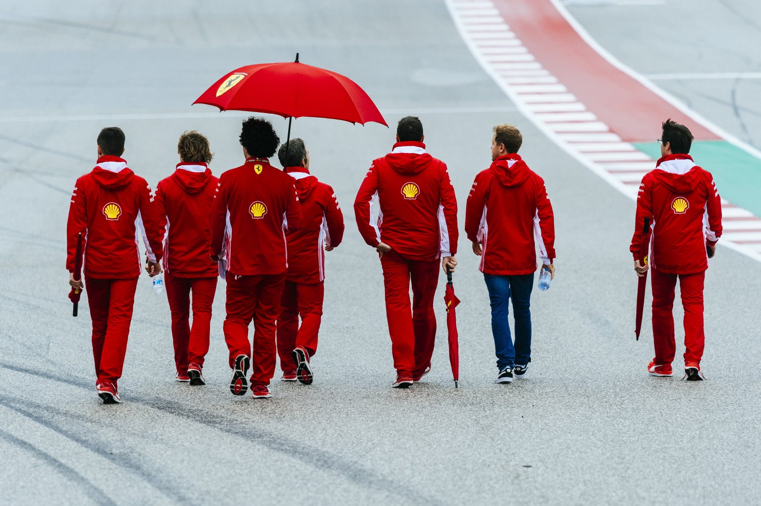 The defeated Ferrari team walks the track in Austin Thursday