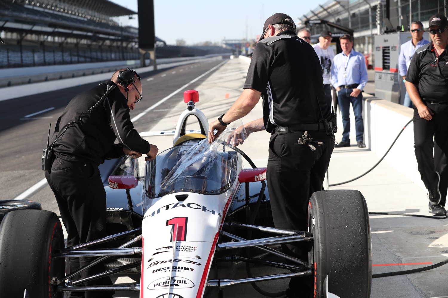 Team Penske removes experimental tear-offs from the windscreen of Josef Newgarden's car during the windscreen test at the Indianapolis Motor Speedway