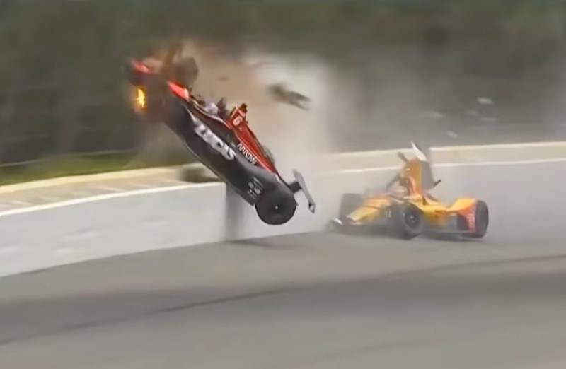 Wickens' car slices thru the fence wire like butter, hits one of the big steel fence poles, and suffers massive injuries to his body, narrowly escaping death - but it is all so unnecessary