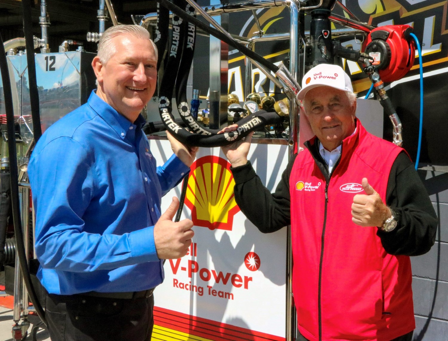 Stephen Dutton (L) and Roger Penske (R) inspect the Pirtek hydraulic hoses that allowed Shell V-Power Racing to win the Pirtek Pitstop Challenge for a second year running.