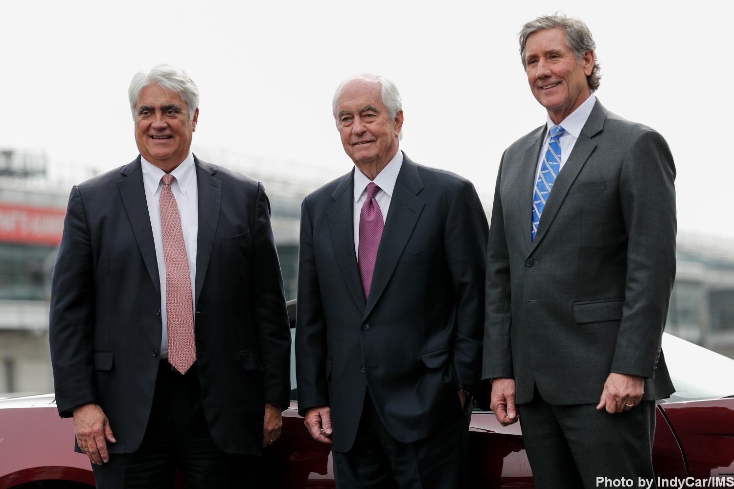 Mark Miles, Roger Penske and Tony George pose on the track after the press conference