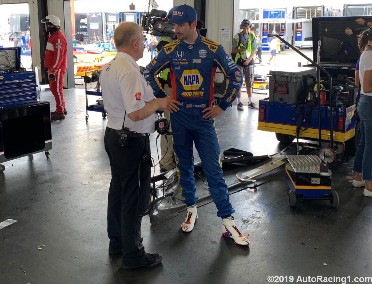ROssi talks to Andretti Autosport COO Rob Edwards while his crew works on his car.