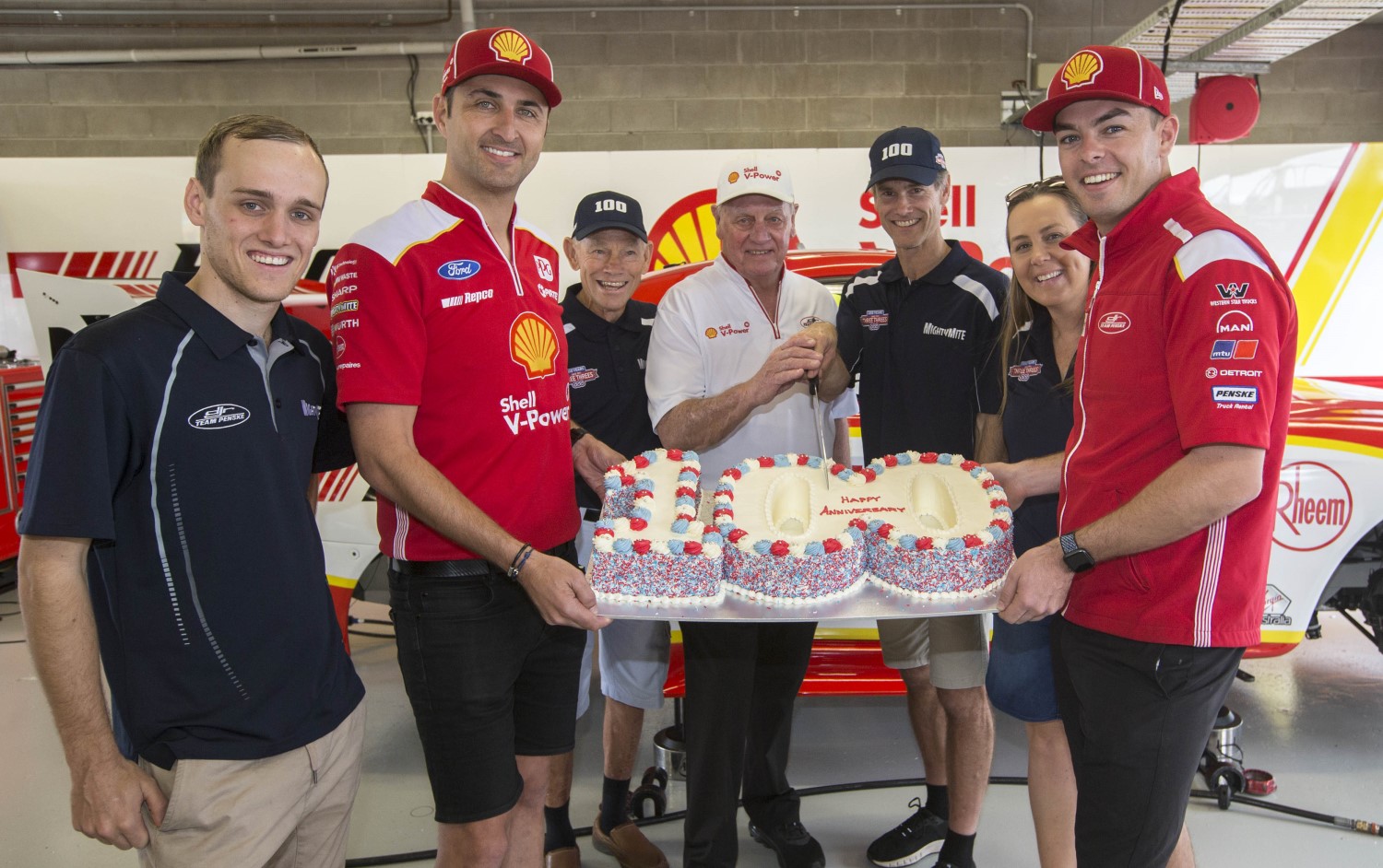 Drivers Fabian Coulthard and Scott McLaughlin hold the 100-years cake
