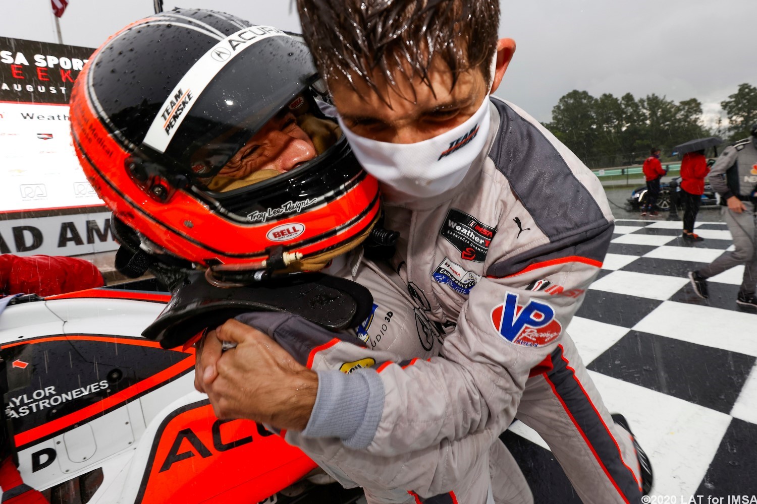 Co-Driver Ricky Taylor cheers teammate Helio Castroneves' winning pass in the rain
