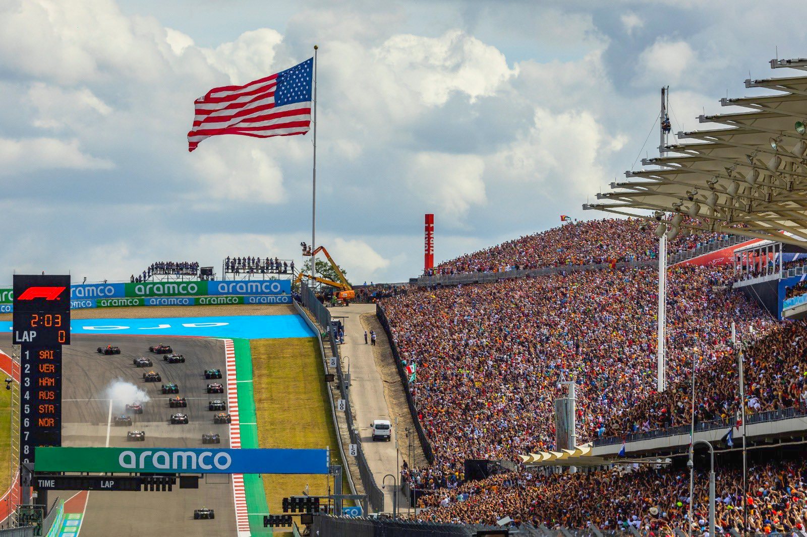 2022 USGP - F1 cars head up the hill toward Turn 1 at the start in front of a massive Turn 1 crowd