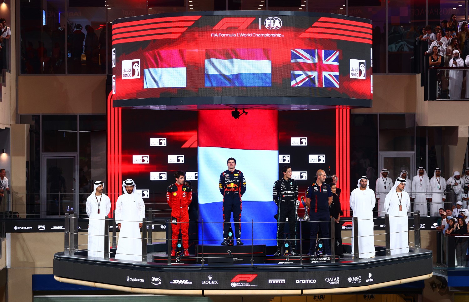 Race winner Max Verstappen of the Netherlands and Oracle Red Bull Racing, Second placed Charles Leclerc of Monaco and Ferrari, Third placed George Russell of Great Britain and Mercedes and Jamie Meades, Head Of Supply Chain Operations at Red Bull Racing celebrate on the podium during the F1 Grand Prix of Abu Dhabi at Yas Marina Circuit on November 26, 2023 in Abu Dhabi, United Arab Emirates. (Photo by Clive Rose/Getty Images) // Getty Images / Red Bull Content Pool