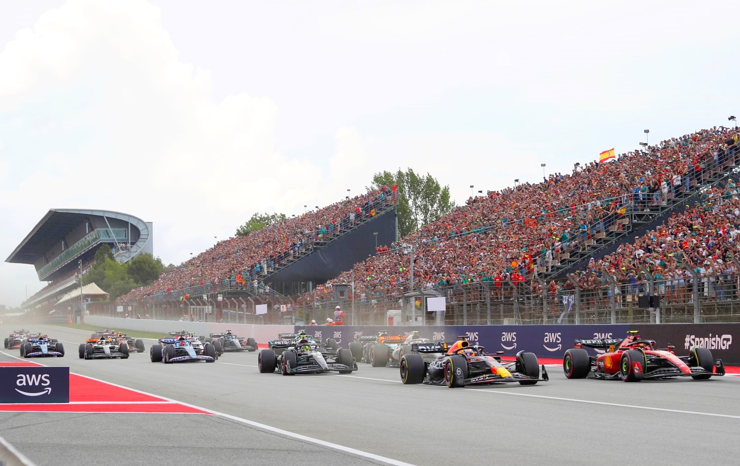Max Verstappen of the Netherlands driving the (1) Oracle Red Bull Racing RB19 leads Carlos Sainz of Spain driving (55) the Ferrari SF-23 and the rest of the field into turn one at the start during the F1 Grand Prix of Spain at Circuit de Barcelona-Catalunya on June 04, 2023 in Barcelona, Spain. (Photo by Peter Fox/Getty Images) // Getty Images / Red Bull Content Pool