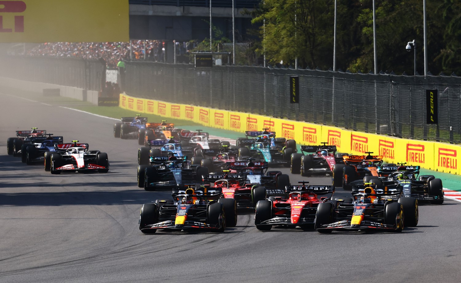 Max Verstappen of the Netherlands driving the (1) Oracle Red Bull Racing RB19 Charles Leclerc of Monaco driving the (16) Ferrari SF-23 and Sergio Perez of Mexico driving the (11) Oracle Red Bull Racing RB19 battle for track position into the first corner at the start of the race during the F1 Grand Prix of Mexico at Autodromo Hermanos Rodriguez on October 29, 2023 in Mexico City, Mexico. (Photo by Mark Thompson/Getty Images) // Getty Images / Red Bull Content Pool