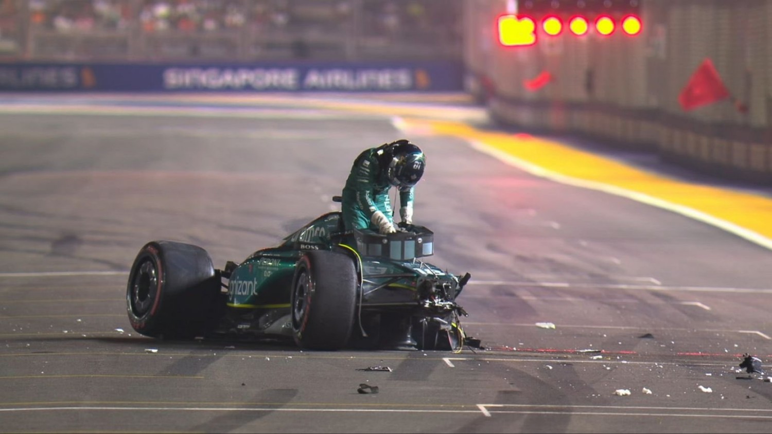 Lance Stroll climbs out of his destroyed Aston Martin