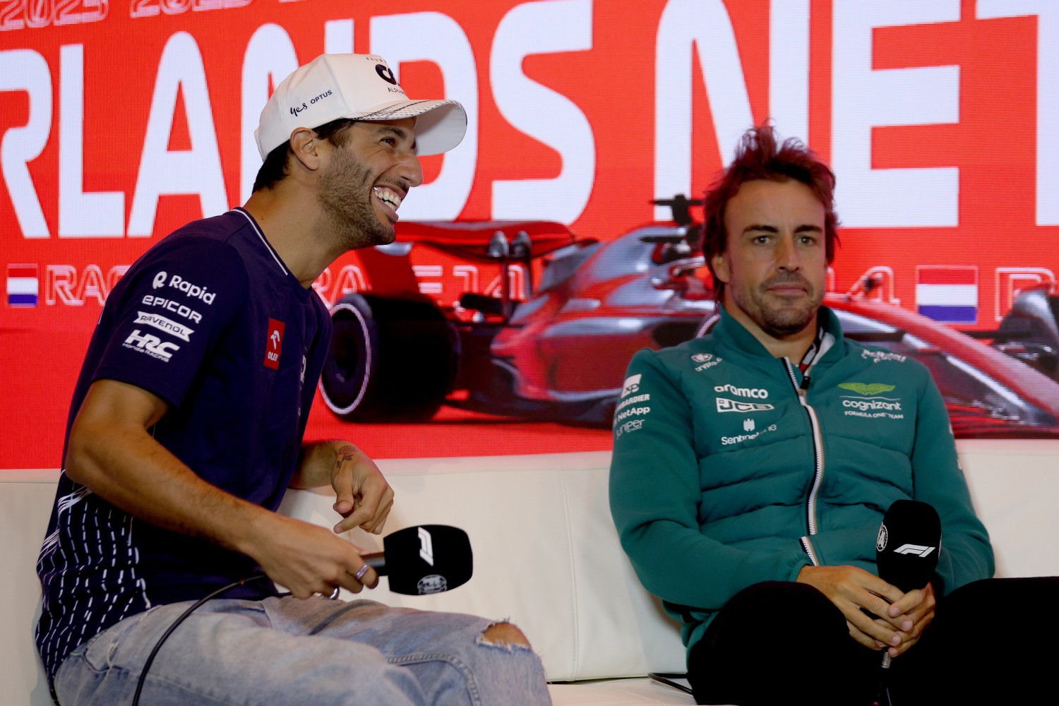 Daniel Ricciardo of Australia and Scuderia AlphaTauri and Fernando Alonso of Spain and Aston Martin F1 Team talk in the Drivers Press Conference during previews ahead of the F1 Grand Prix of The Netherlands at Circuit Zandvoort on August 24, 2023 in Zandvoort, Netherlands. (Photo by Dean Mouhtaropoulos/Getty Images) // Getty Images / Red Bull Content Pool // 