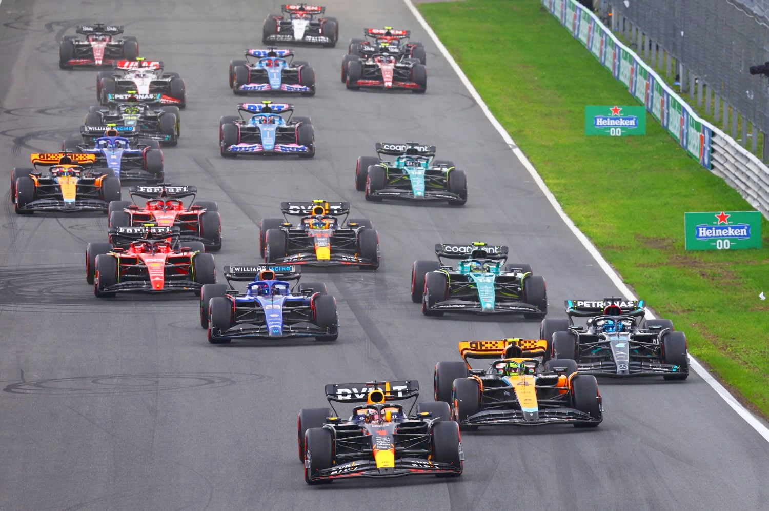 Max Verstappen of the Netherlands driving the (1) Oracle Red Bull Racing RB19 leads Lando Norris of Great Britain driving the (4) McLaren MCL60 Mercedes, George Russell of Great Britain driving the (63) Mercedes AMG Petronas F1 Team W14 and the rest of the field into turn one at the start during the F1 Grand Prix of The Netherlands at Circuit Zandvoort on August 27, 2023 in Zandvoort, Netherlands. (Photo by Mark Thompson/Getty Images) // Getty Images / Red Bull Content Pool