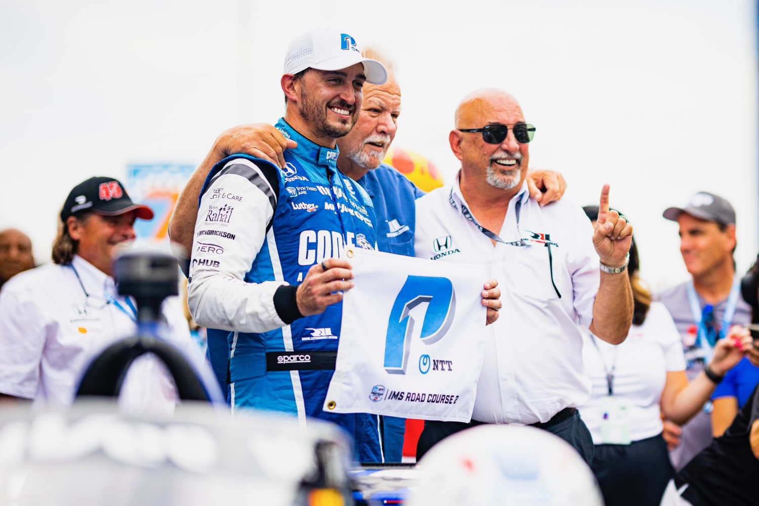 Graham Rahal wins pole for Gallagher GP - celebrates with team co-owners Mike Lanigan and Bobby Rahal