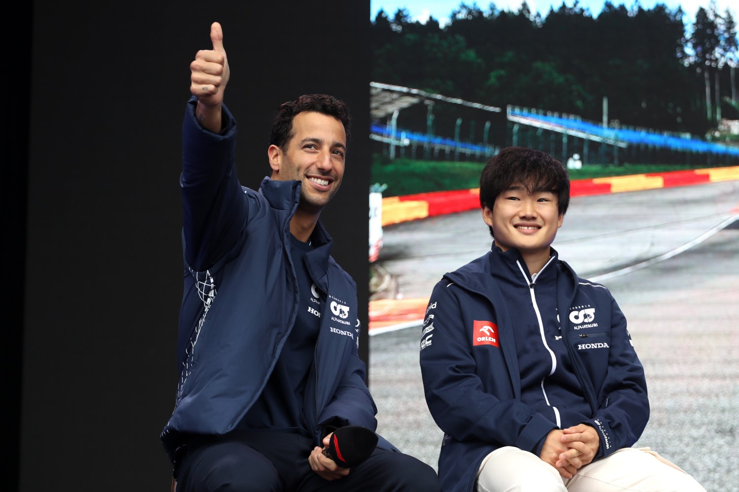 Daniel Ricciardo of Australia and Scuderia AlphaTauri and Yuki Tsunoda of Japan and Scuderia AlphaTauri talk to the crowd on the fan stage prior to practice ahead of the F1 Grand Prix of Belgium at Circuit de Spa-Francorchamps on July 28, 2023 in Spa, Belgium. (Photo by Peter Fox/Getty Images) // Getty Images / Red Bull Content Pool