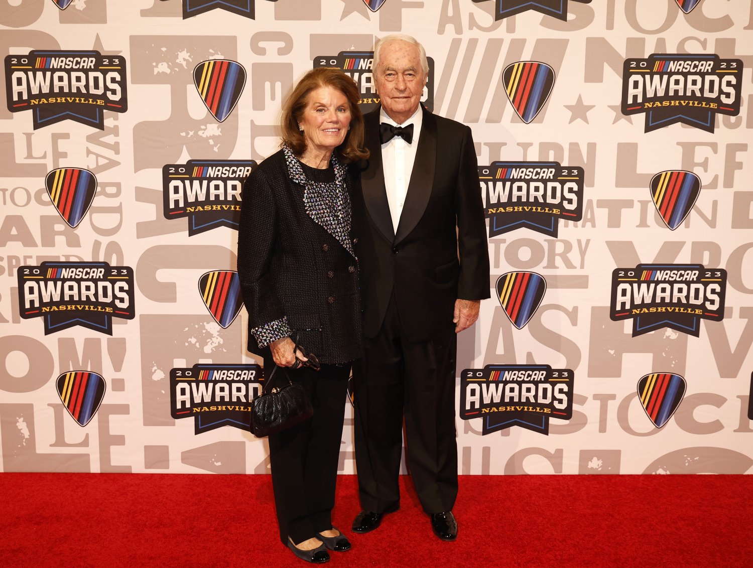 Team Penske owner, Roger Penske and wife, Kathy Penske pose for photos on the red carpet next to the Bill France NASCAR Cup Series Championship trophy prior to the NASCAR Awards and Champion Celebration at the Music City Center on November 30, 2023 in Nashville, Tennessee. (Photo by Chris Graythen/Getty Images)