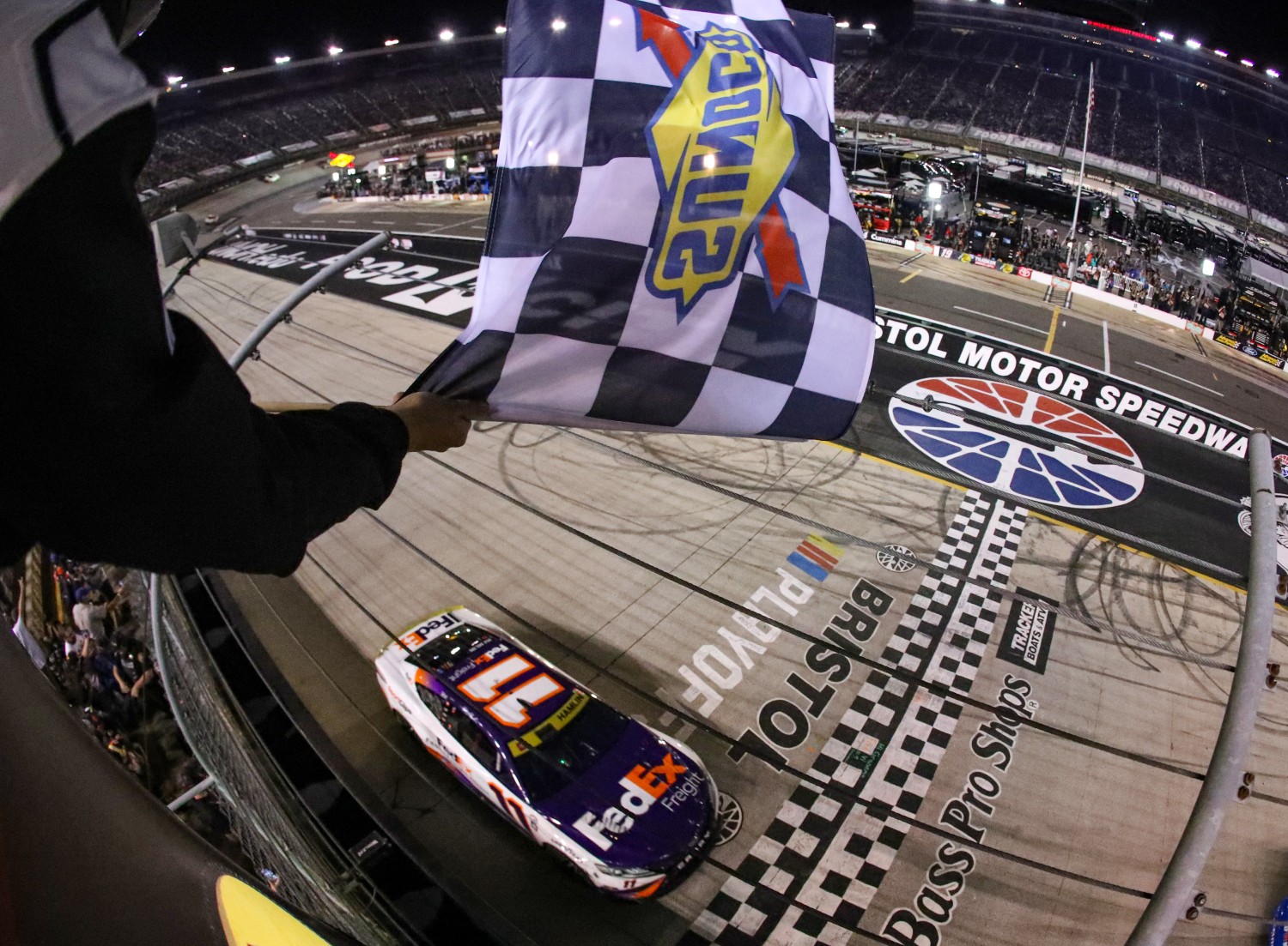 Denny Hamlin, driver of the #11 FedEx Freight Direct Toyota, takes the checkered flag to win the NASCAR Cup Series Bass Pro Shops Night Race at Bristol Motor Speedway on September 16, 2023 in Bristol, Tennessee. (Photo by Meg Oliphant/Getty Images)