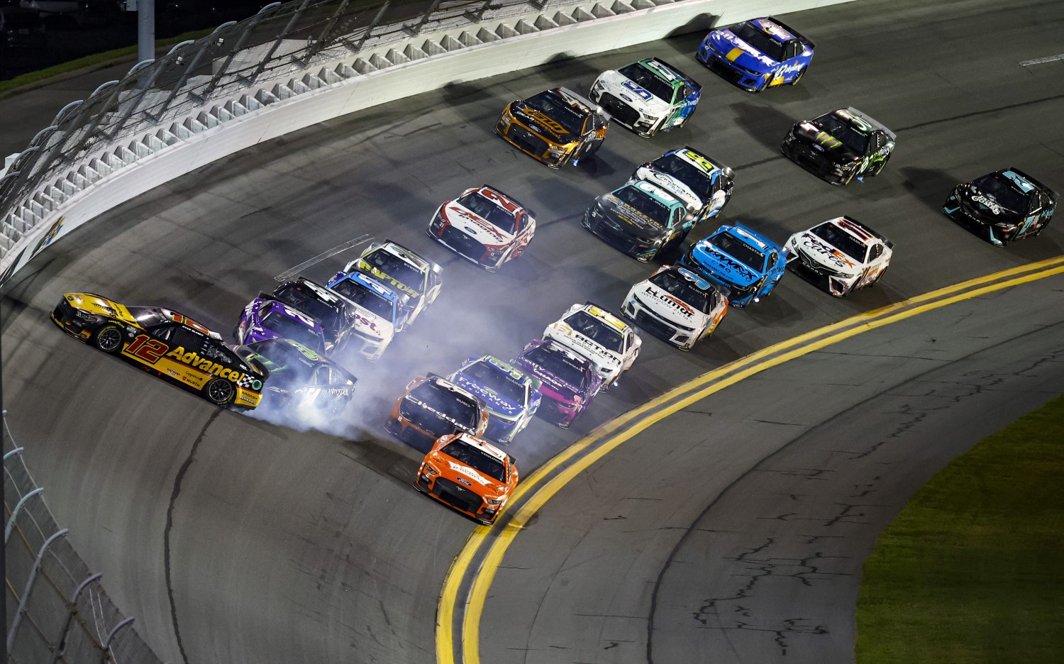 Ryan Blaney, driver of the #12 Advance Auto Parts Ford, Ty Gibbs, driver of the #54 Monster Energy Toyota, and Christopher Bell, driver of the #20 Yahoo! Toyota, spin after an on-track incident during the NASCAR Cup Series Coke Zero Sugar 400 at Daytona International Speedway on August 26, 2023 in Daytona Beach, Florida. (Photo by James Gilbert/Getty Images)