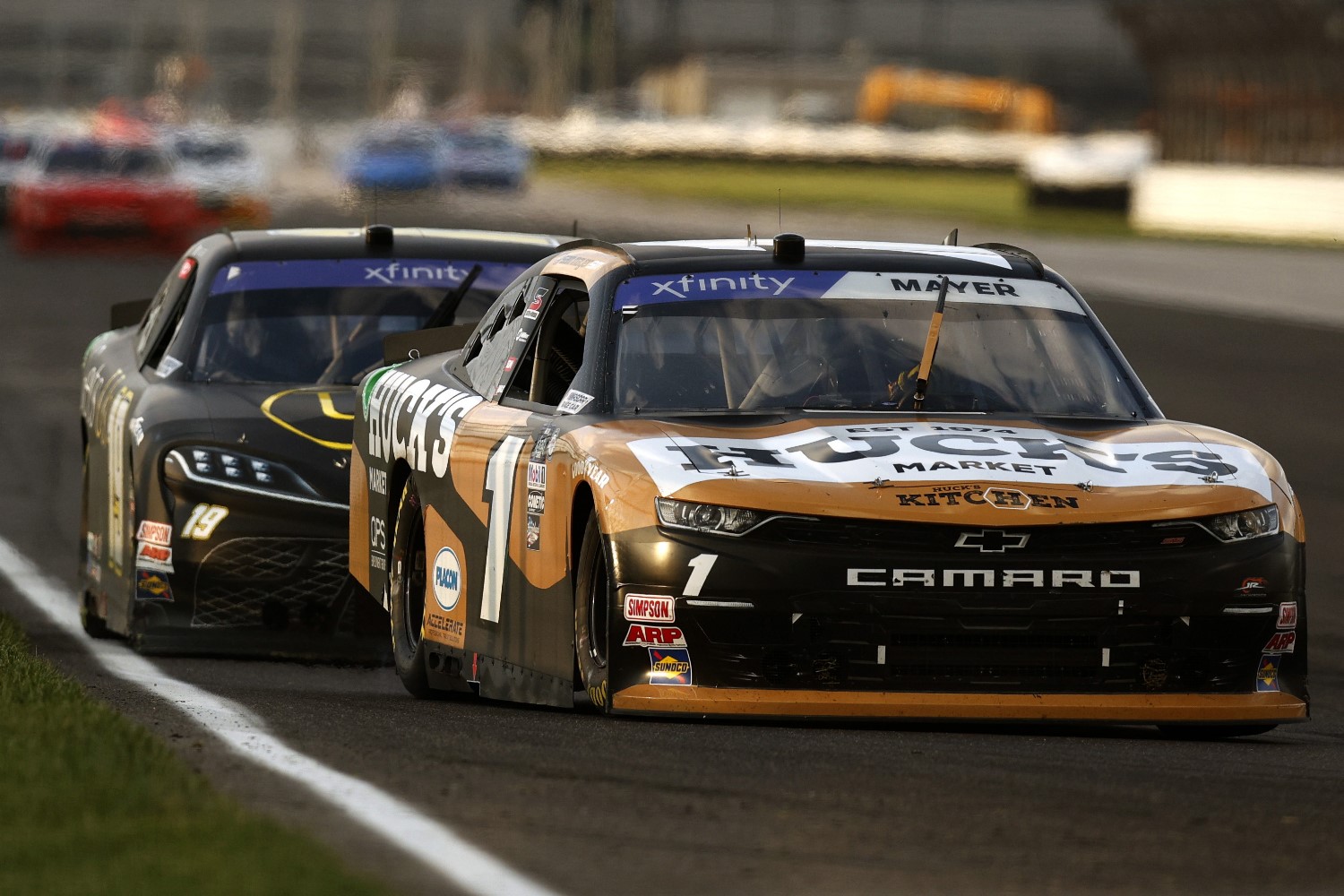 Sam Mayer, driver of the #1 Huck's Market Chevrolet, and Ty Gibbs, driver of the #19 He Gets Us Toyota, race during the NASCAR Xfinity Series Pennzoil 150 at the Brickyard at Indianapolis Motor Speedway on August 12, 2023 in Indianapolis, Indiana. (Photo by Sean Gardner/Getty Images)