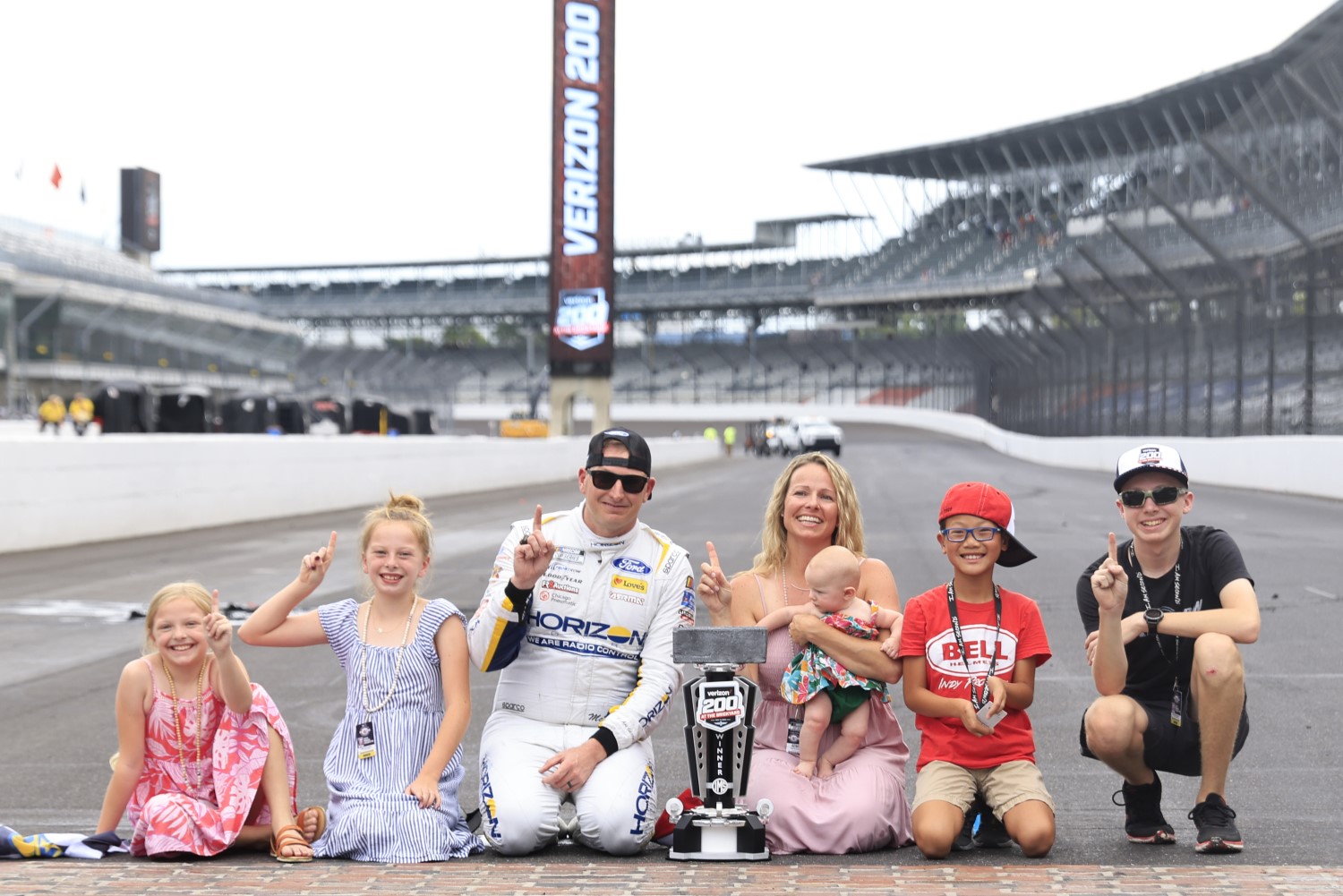 Michael McDowell, driver of the #34 Horizon Hobby Ford, and his family celebrate at the bricks on track after winning the NASCAR Cup Series Verizon 200 at the Brickyard at Indianapolis Motor Speedway on August 13, 2023 in Indianapolis, Indiana. (Photo by Justin Casterline/Getty Images)