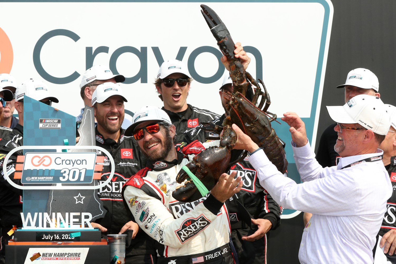 Martin Truex Jr., driver of the #19 Reser's Fine Foods Toyota, is presented Loudon the Lobster in victory lane after winning the NASCAR Cup Series Crayon 301 at New Hampshire Motor Speedway on July 17, 2023 in Loudon, New Hampshire.