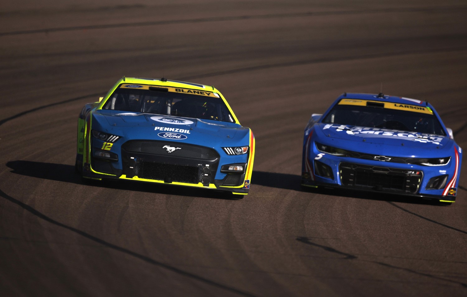 Ryan Blaney, driver of the #12 Menards/Dutch Boy Ford, and Kyle Larson, driver of the #5 HendrickCars.com Chevrolet, race during the NASCAR Cup Series Championship at Phoenix Raceway on November 05, 2023 in Avondale, Arizona. (Photo by Sean Gardner/Getty Images)