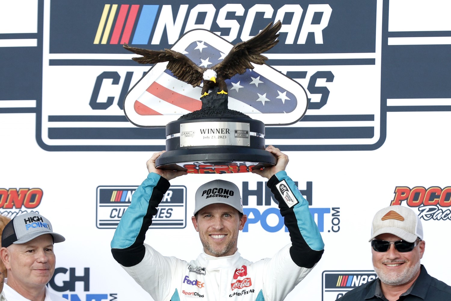 Denny Hamlin, driver of the #11 Mavis Tires & Brakes Toyota, lifts the HighPoint.com 400 trophy in victory lane after winning the NASCAR Cup Series HighPoint.com 400 at Pocono Raceway on July 23, 2023 in Long Pond, Pennsylvania. (Photo by Sean Gardner/Getty Images)