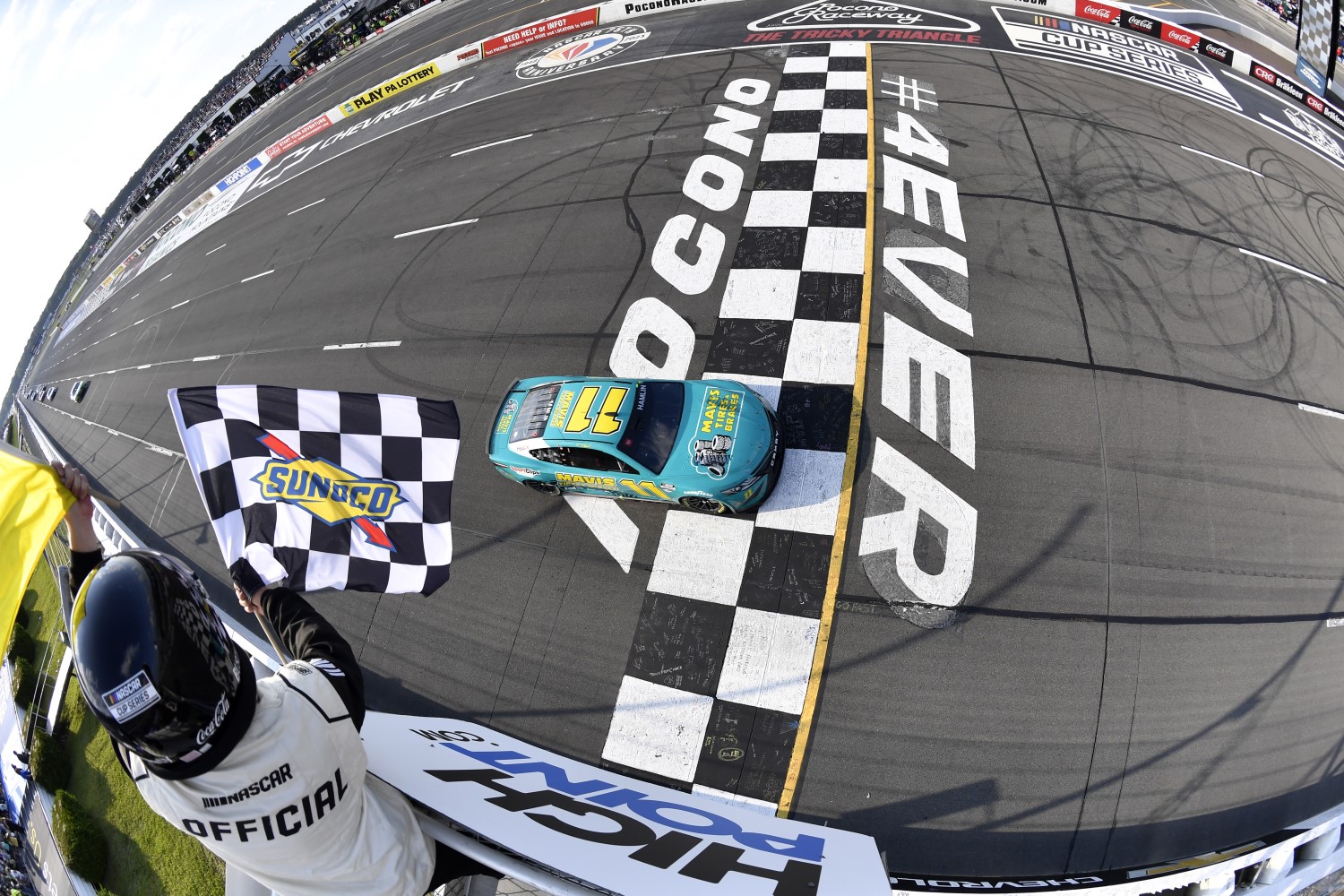 Denny Hamlin, driver of the #11 Mavis Tires & Brakes Toyota, takes the checkered flag under caution to win the NASCAR Cup Series HighPoint.com 400 at Pocono Raceway on July 23, 2023 in Long Pond, Pennsylvania. (Photo by Logan Riely/Getty Images)