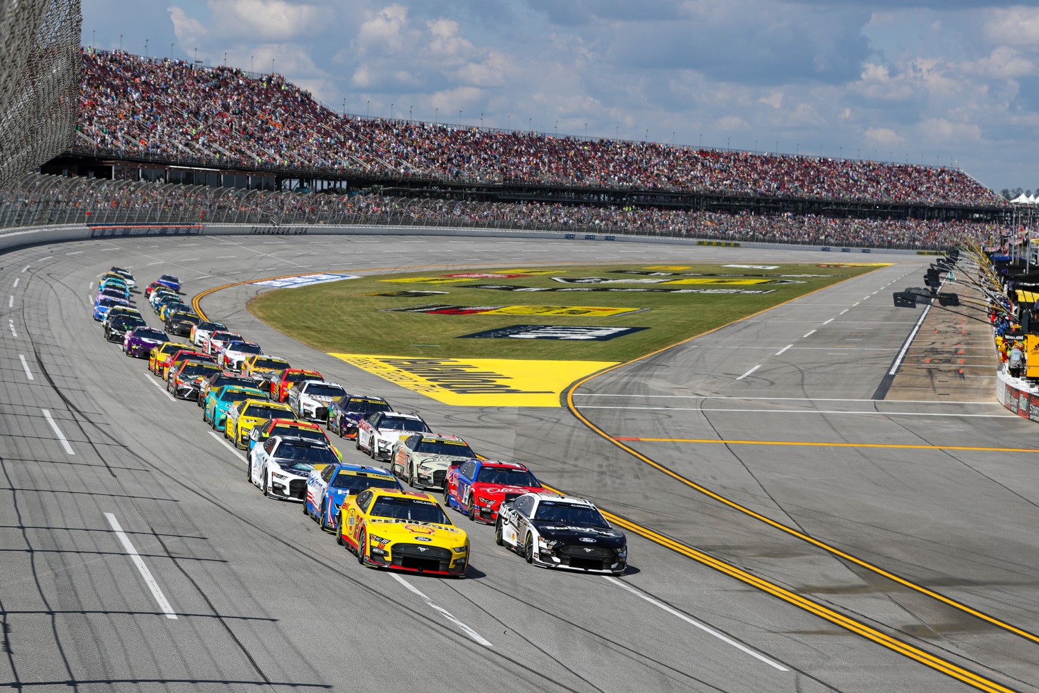 Aric Almirola, driver of the #10 Smithfield Ford, and Joey Logano, driver of the #22 Shell Pennzoil Ford, race during the NASCAR Cup Series YellaWood 500 at Talladega Superspeedway on October 01, 2023 in Talladega, Alabama. (Photo by Meg Oliphant/Getty Images)