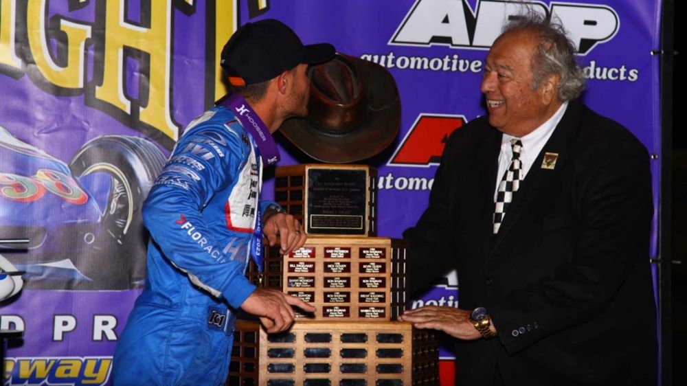 Kyle Larson (left) kisses the Aggie Hat trophy as J.C. Agajanian Jr. looks on after Larson captured Saturday night's 82nd running of the ARP Turkey Night Grand Prix Presented by the West Coast Stock Car/Motorsports Hall of Fame at California's Ventura Raceway. Rich Forman Photo
