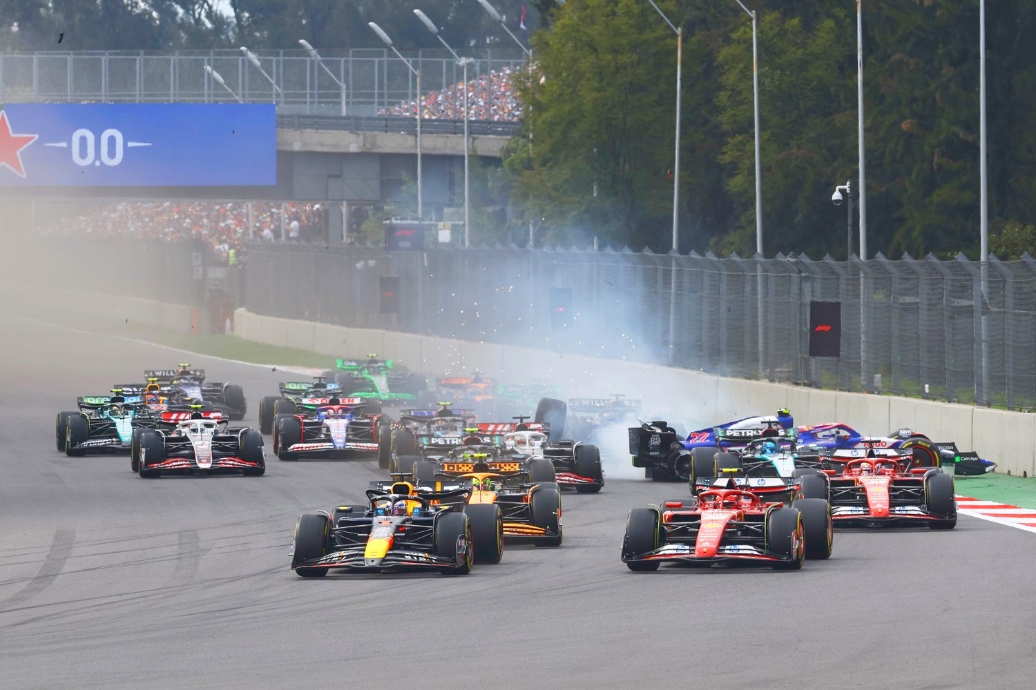 Max Verstappen of the Netherlands driving the (1) Oracle Red Bull Racing RB20 leads Carlos Sainz of Spain driving (55) the Ferrari SF-24 and Lando Norris of Great Britain driving the (4) McLaren MCL38 Mercedes into turn 1 at the start during the F1 Grand Prix of Mexico at Autodromo Hermanos Rodriguez on October 27, 2024 in Mexico City, Mexico. (Photo by Mark Thompson/Getty Images) // Getty Images / Red Bull Content Pool //