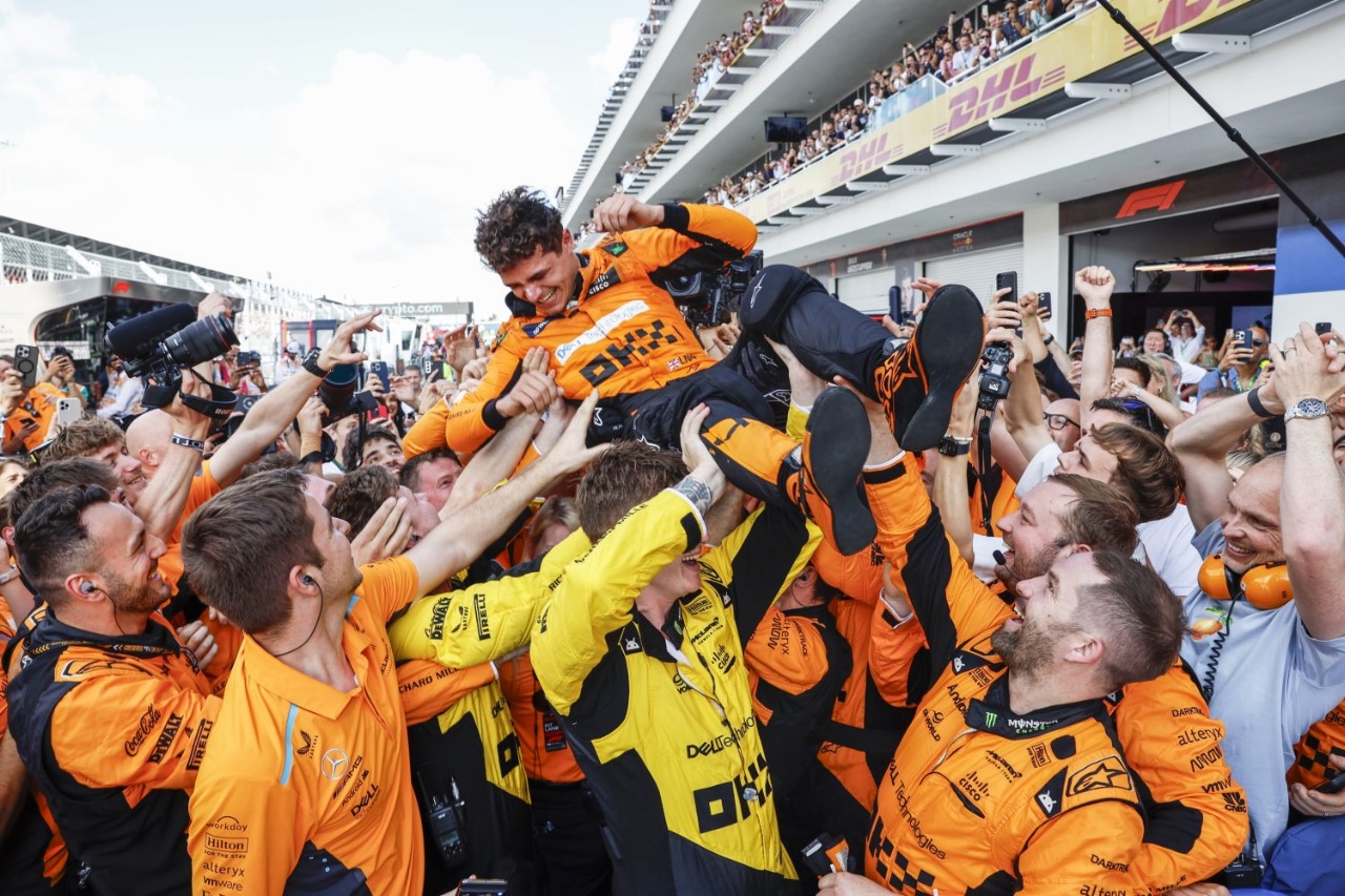 Race winner Lando Norris body surfs over team