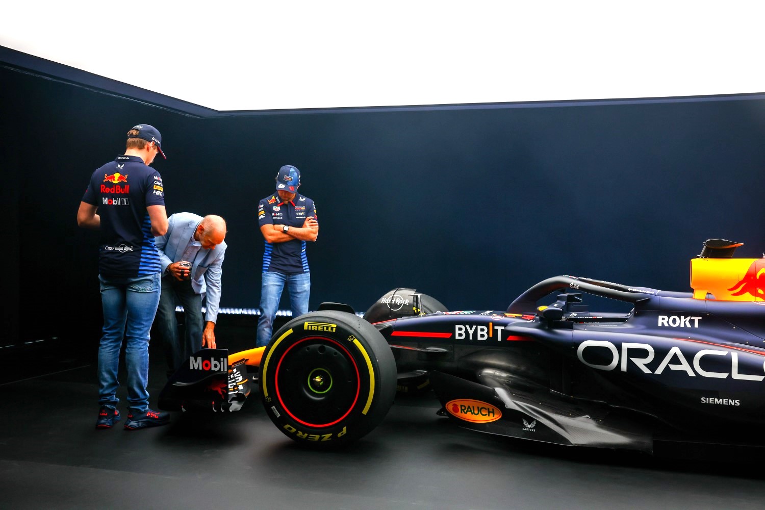 Max Verstappen of the Netherlands and Oracle Red Bull Racing and Sergio Perez of Mexico and Oracle Red Bull Racing look at the RB20 with Adrian Newey, the Chief Technical Officer of Red Bull Racing during the Oracle Red Bull Racing RB20 car launch at Red Bull Racing Factory on February 15, 2024 in Milton Keynes, England. (Photo by Mark Thompson/Getty Images for Red Bull Racing)