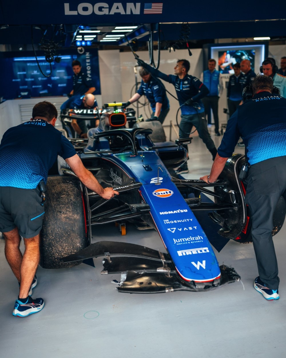 The Williams mechanics get Sargeant's wadded up car back into the garage.