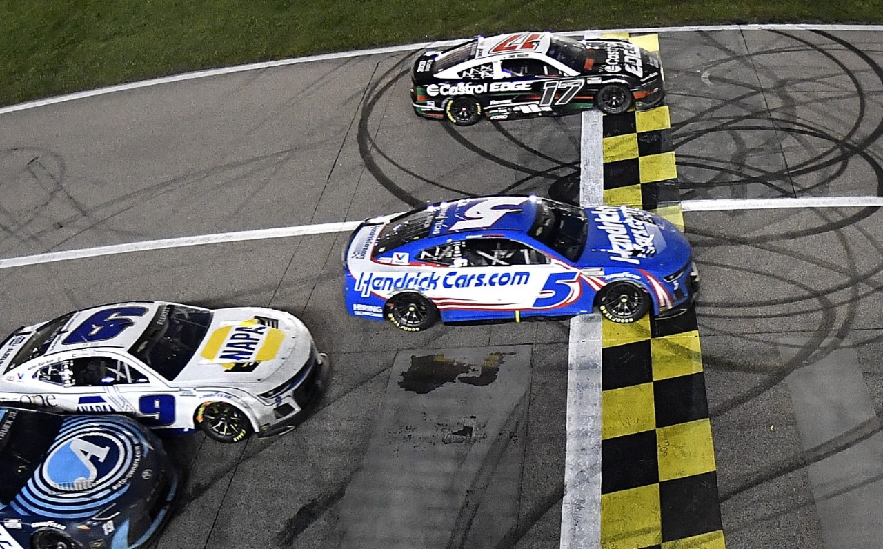 Kyle Larson, driver of the #5 HendrickCars.com Chevrolet, takes the checkered flag over Chris Buescher, driver of the #17 Castrol Edge Ford, to win the NASCAR Cup Series AdventHealth 400 at Kansas Speedway on May 05, 2024 in Kansas City, Kansas. (Photo by Logan Riely/Getty Images for NASCAR)