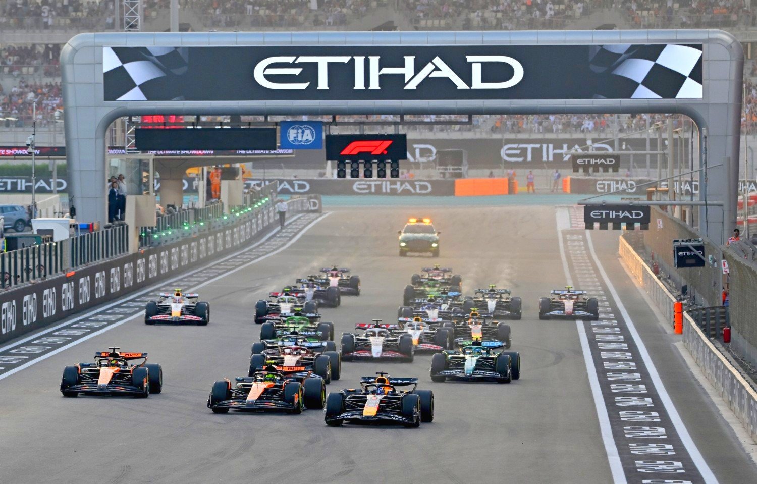 Max Verstappen of the Netherlands driving the (1) Oracle Red Bull Racing RB21 leads Lando Norris of Great Britain driving the (4) McLaren MCL39 Mercedes Oscar Piastri of Australia driving the (81) McLaren MCL39 Mercedes and the rest of the field at the start during the F1 Grand Prix of Abu Dhabi at Yas Marina Circuit on December 07, 2025 in Abu Dhabi, United Arab Emirates. (Photo by Michael Potts/LAT Images) // Getty Images / Red Bull Content Pool //