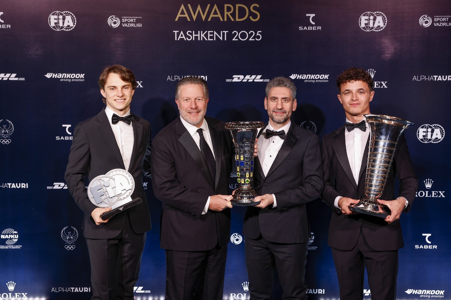 (L to R) Oscar Piastri, Zak Brown, Andrea Stella and Lando Norris show off their hardware at the 2025 FIA Awards Ceremony. Image supplied by the FIA