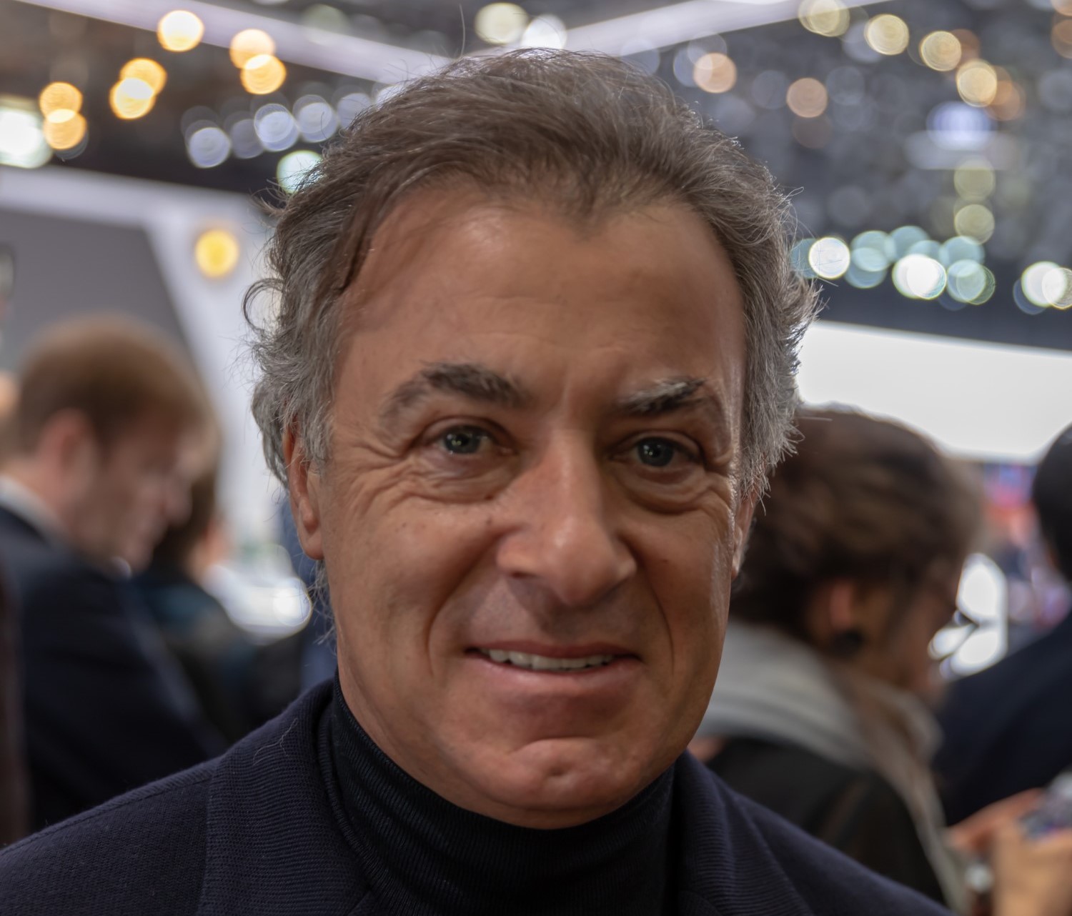 Jean Alesi at Geneva International Motor Show 2019, Le Grand-Saconnex. Photo by Matti Blume via Wikipedia. This file is licensed under the Creative Commons Attribution-Share Alike 4.0 International license. You must give appropriate credit, provide a link to the license, and indicate if changes were made. You may do so in any reasonable manner, but not in any way that suggests the licensor endorses you or your use.