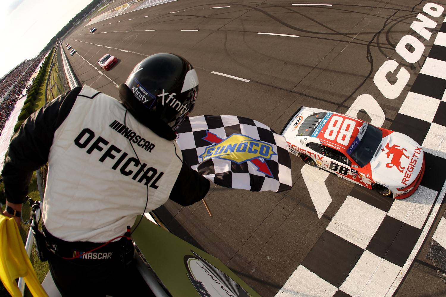 Connor Zilisch, driver of the #88 Registix Chevrolet, takes the checkered flag to win the NASCAR Xfinity Series Explore the Pocono Mountains 250 at Pocono Raceway on June 21, 2025 in Long Pond, Pennsylvania. (Photo by Meg Oliphant/Getty Images)