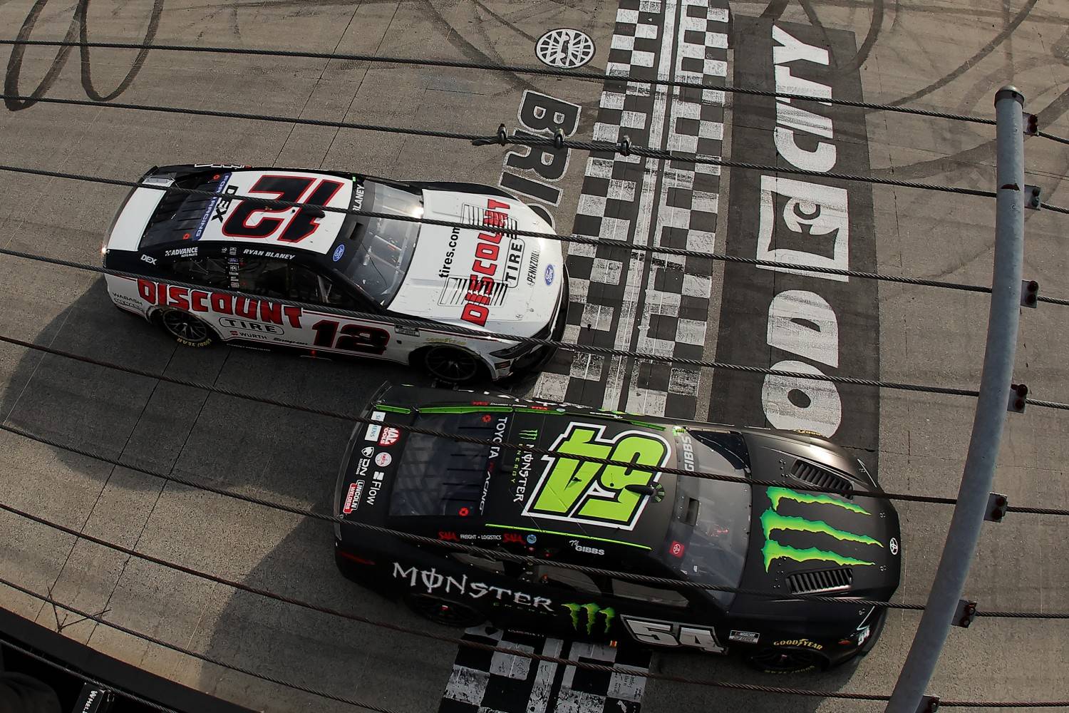 Ty Gibbs, driver of the #54 Monster Energy Toyota, crosses the finish line ahead of Ryan Blaney, driver of the #12 Discount Tire Ford, to win the NASCAR Cup Series Food City 500 at Bristol Motor Speedway on April 12, 2026 in Bristol, Tennessee. (Photo by Jonathan Bachman/Getty Images)