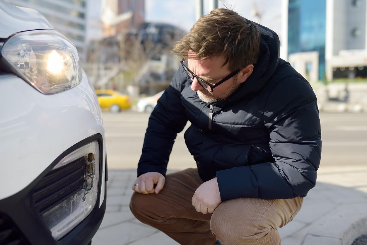 Man inspecting damaged car